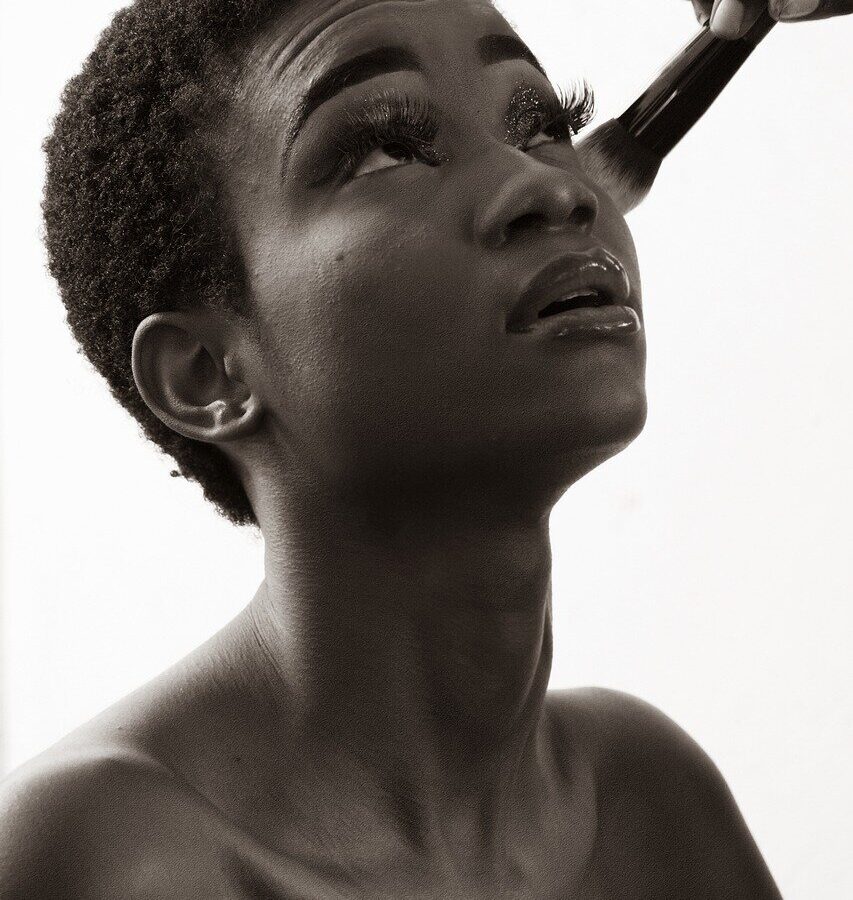 Makeup artist applying foundation to a client's face